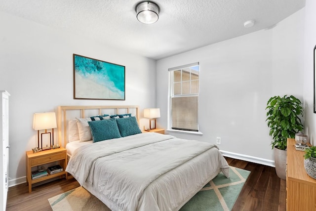 bedroom featuring a textured ceiling and dark wood-type flooring