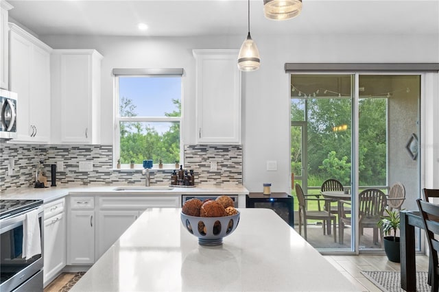 kitchen featuring white cabinetry, sink, light hardwood / wood-style flooring, and plenty of natural light