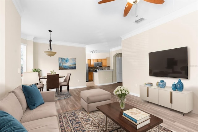 living room with ceiling fan, light hardwood / wood-style flooring, and ornamental molding