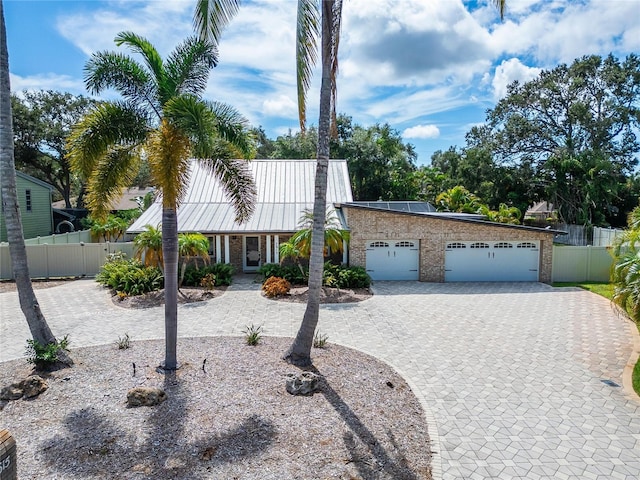 view of front of property featuring a garage and solar panels