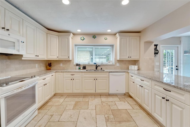 kitchen featuring tasteful backsplash, sink, white cabinets, kitchen peninsula, and white appliances