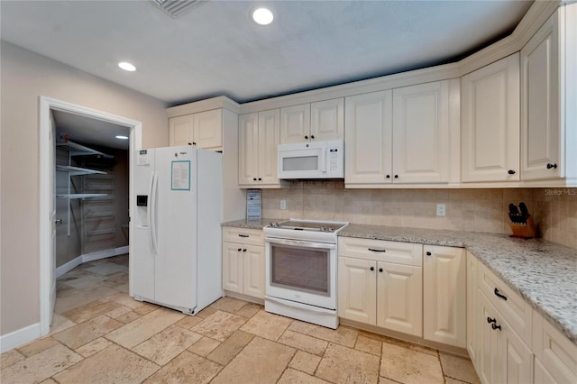 kitchen with decorative backsplash, white appliances, and light stone counters