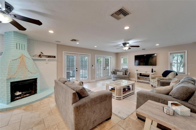 living room featuring ceiling fan, a fireplace, and plenty of natural light