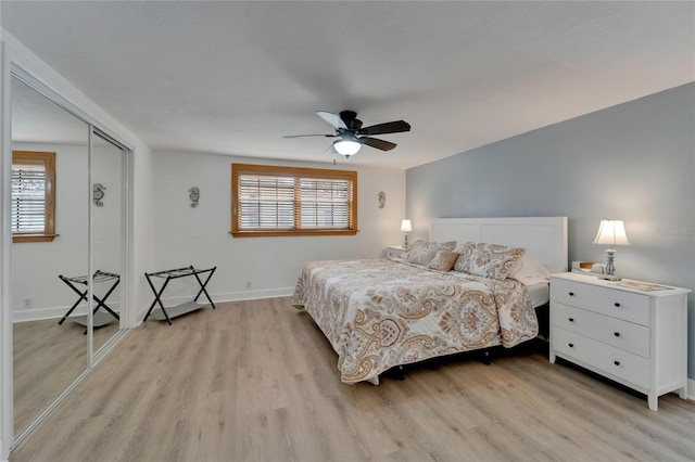 bedroom with ceiling fan, a closet, light wood-type flooring, and multiple windows