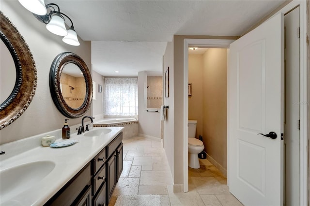 bathroom featuring a bath, vanity, and toilet