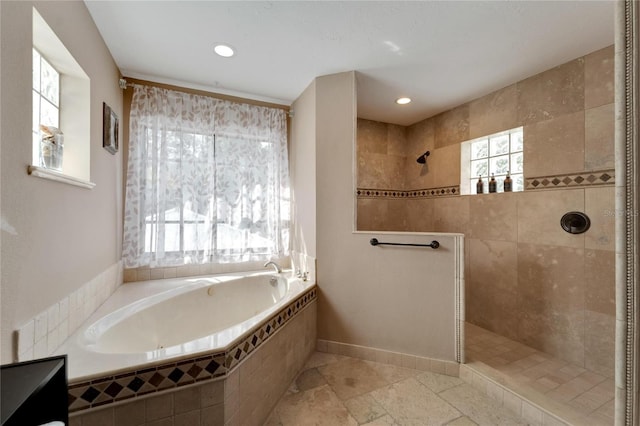 bathroom featuring plenty of natural light and separate shower and tub