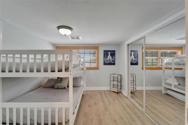 bedroom with wood-type flooring and a closet