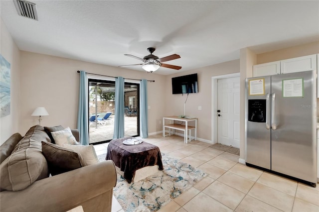 tiled living room with ceiling fan and a textured ceiling