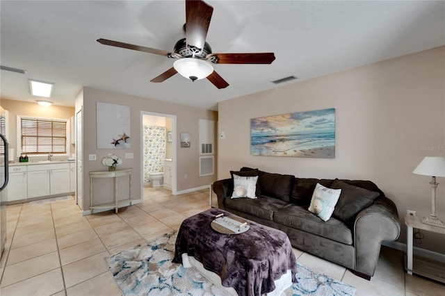 living room featuring ceiling fan, sink, and light tile patterned floors