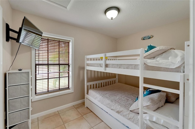 bedroom featuring a textured ceiling and tile patterned flooring