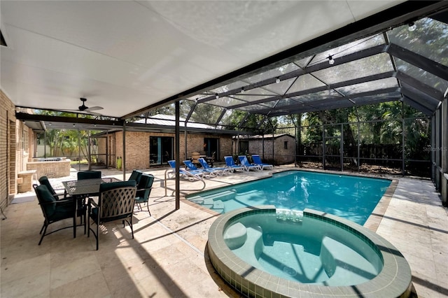 view of pool with an in ground hot tub, glass enclosure, a patio, and ceiling fan