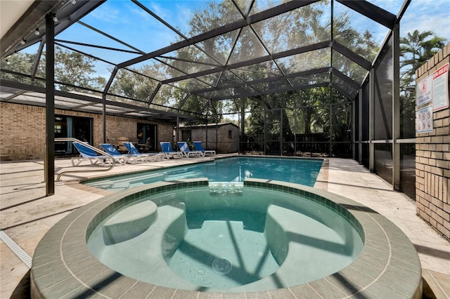 view of swimming pool featuring glass enclosure, an in ground hot tub, and a patio