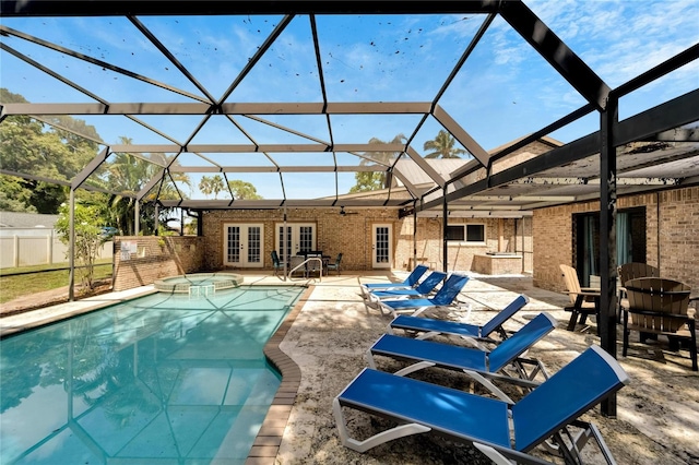 view of pool with french doors, glass enclosure, and a patio area