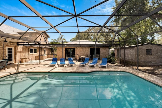 view of swimming pool with a lanai, a storage shed, and a patio area