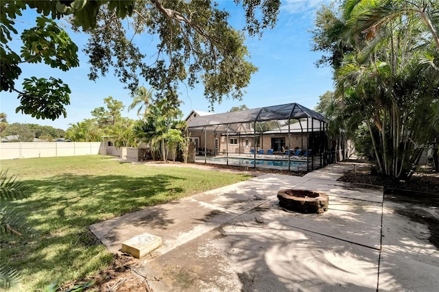 view of yard featuring a lanai, a patio, a fenced in pool, and an outdoor fire pit