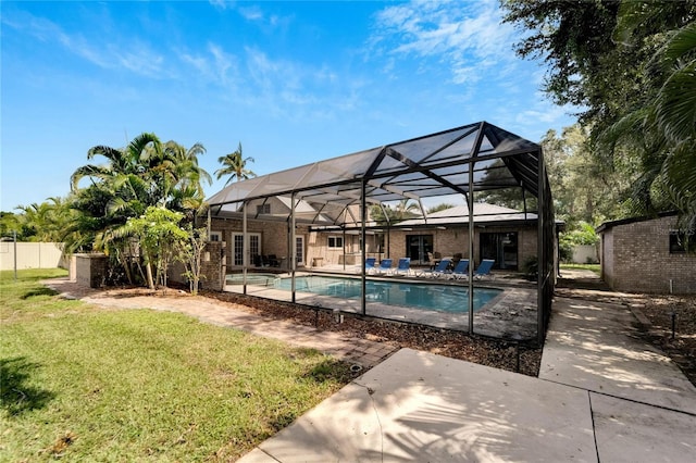 view of pool with a patio, a lawn, and a lanai