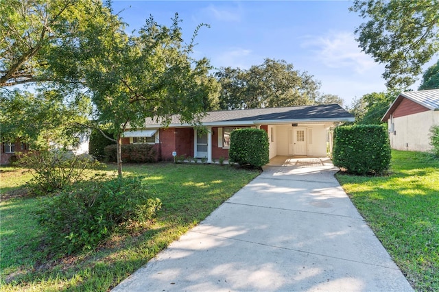 ranch-style home featuring a carport and a front lawn