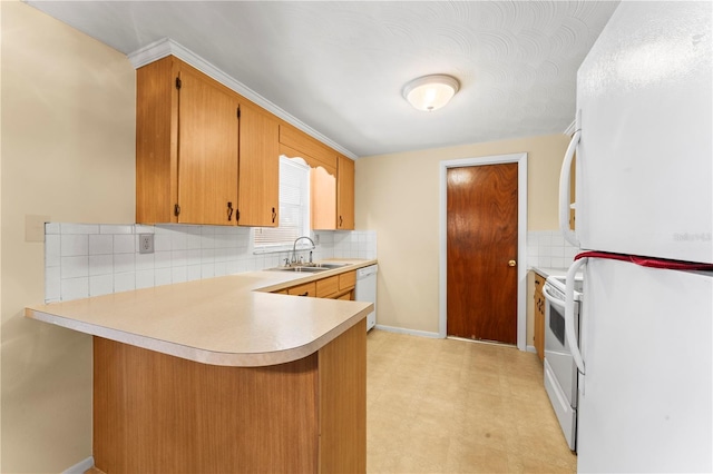 kitchen with decorative backsplash, white appliances, sink, and kitchen peninsula