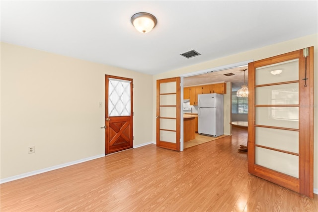 foyer entrance with light hardwood / wood-style flooring and a healthy amount of sunlight