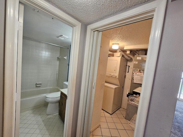 full bathroom featuring tile patterned floors, toilet, tiled shower / bath combo, vanity, and a textured ceiling