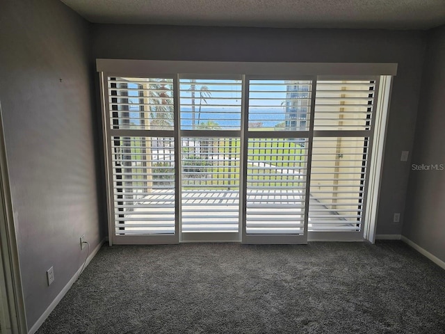 carpeted spare room with a textured ceiling