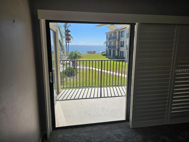 doorway featuring a water view and carpet floors