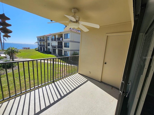 balcony featuring a water view and ceiling fan