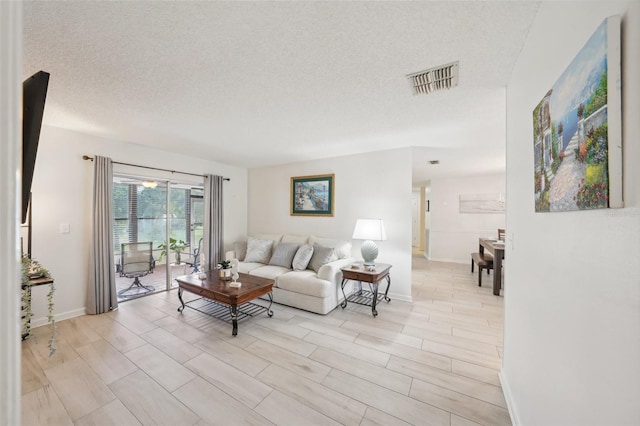 living room with a textured ceiling and light hardwood / wood-style floors