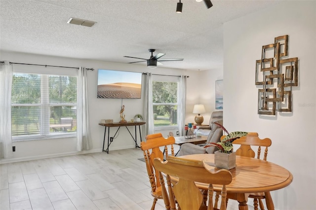 dining space with a textured ceiling, light hardwood / wood-style floors, and ceiling fan