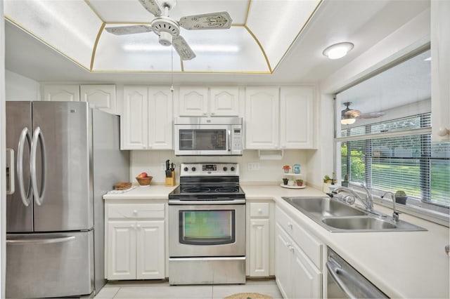 kitchen featuring white cabinets, sink, light tile patterned floors, ceiling fan, and appliances with stainless steel finishes