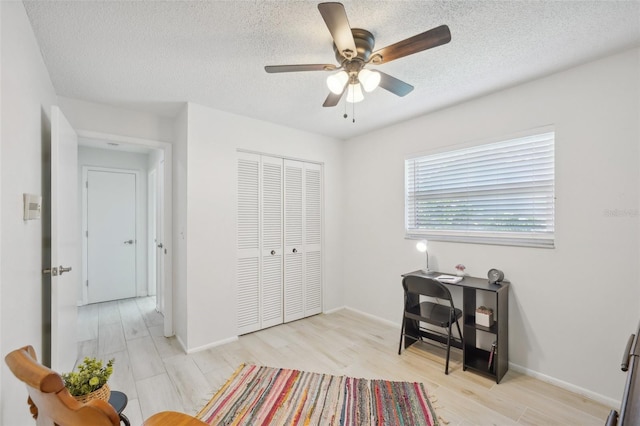 office with ceiling fan, a textured ceiling, and light hardwood / wood-style floors