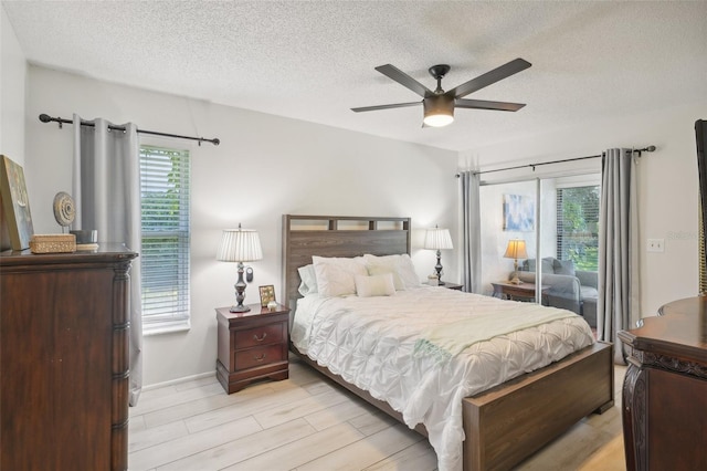 bedroom featuring light hardwood / wood-style floors, ceiling fan, and a textured ceiling