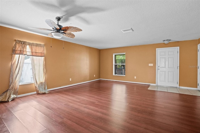 spare room with plenty of natural light, ceiling fan, hardwood / wood-style flooring, and a textured ceiling