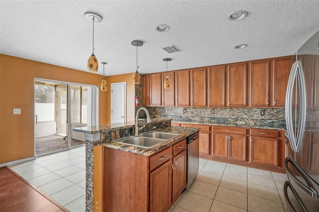 kitchen with decorative light fixtures, light tile patterned flooring, appliances with stainless steel finishes, and sink