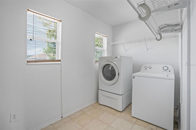 clothes washing area with washing machine and dryer and a wealth of natural light