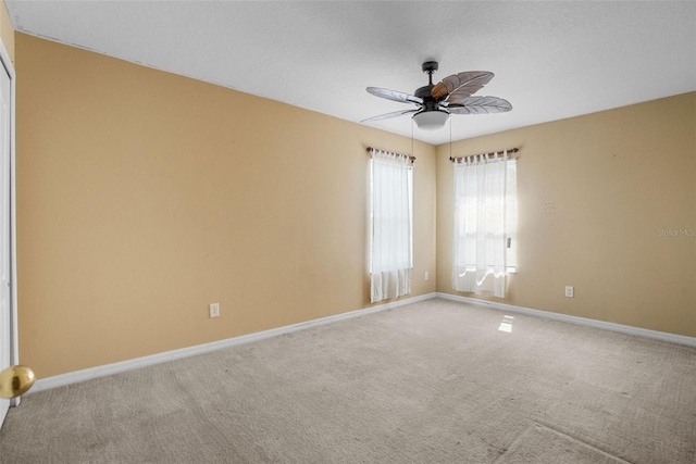 carpeted empty room featuring ceiling fan