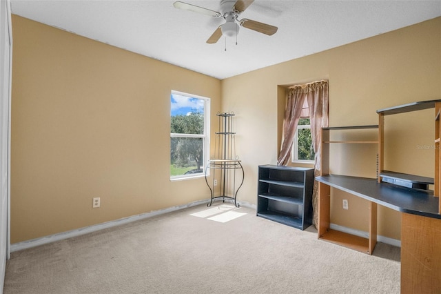 interior space with light carpet and ceiling fan