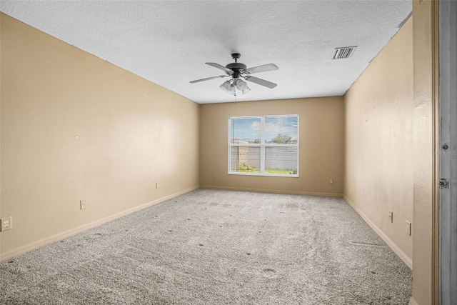 empty room featuring ceiling fan, light colored carpet, and a textured ceiling