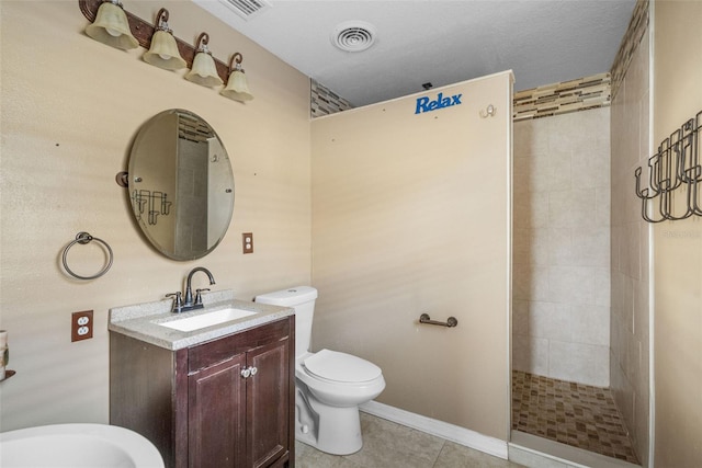 bathroom with tile patterned flooring, a textured ceiling, tiled shower, vanity, and toilet