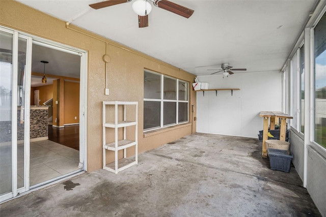 unfurnished sunroom with ceiling fan