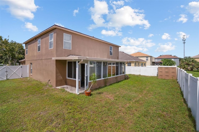 rear view of house with a sunroom and a yard