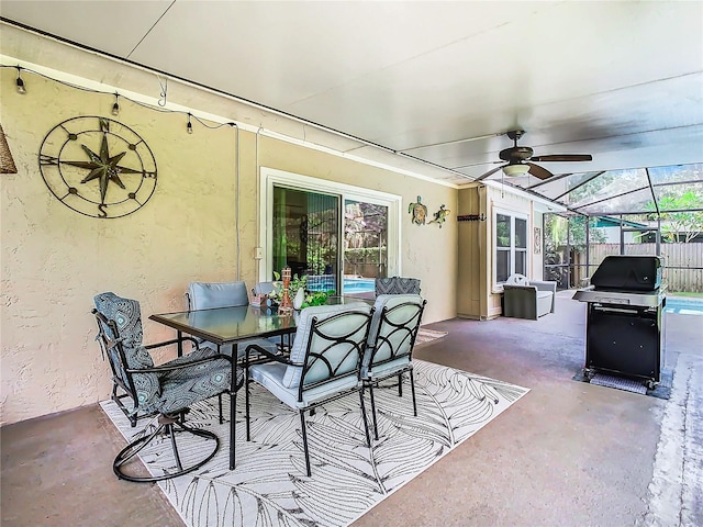 view of patio featuring ceiling fan, a grill, and glass enclosure