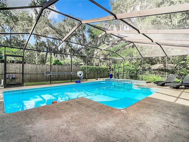 view of swimming pool featuring glass enclosure and a patio area