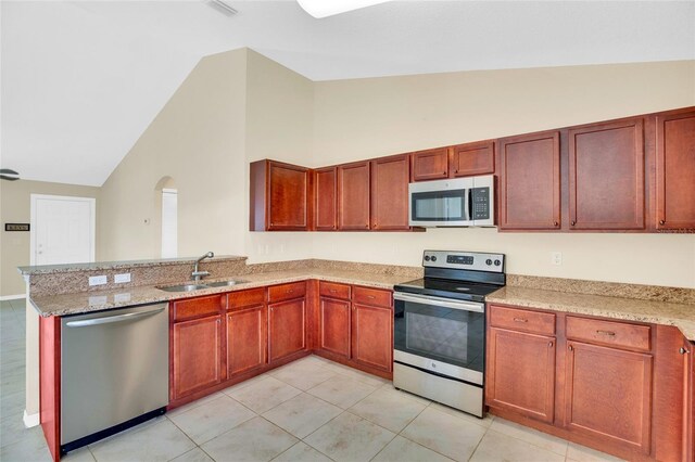 kitchen featuring appliances with stainless steel finishes, sink, light tile patterned floors, and light stone counters