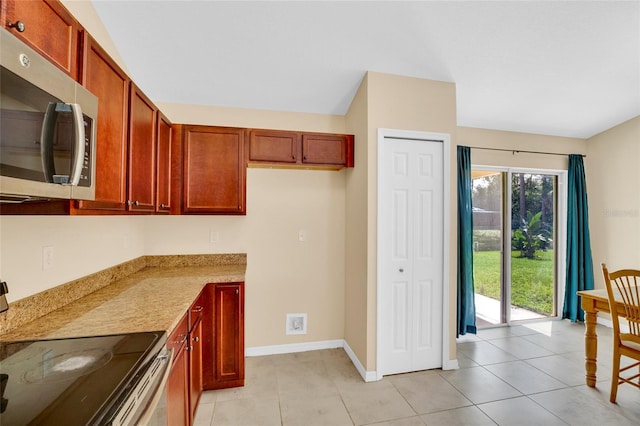 kitchen featuring light stone countertops, light tile patterned floors, and electric range