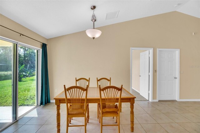 dining room featuring light tile patterned floors and vaulted ceiling