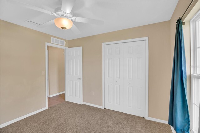 unfurnished bedroom with ceiling fan, a closet, and carpet flooring