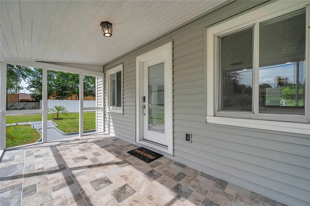 unfurnished sunroom with lofted ceiling and wood ceiling