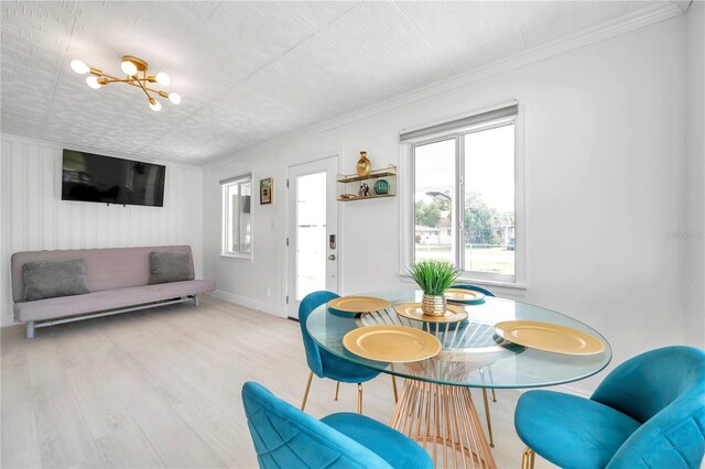 dining area with crown molding, light hardwood / wood-style floors, and a chandelier