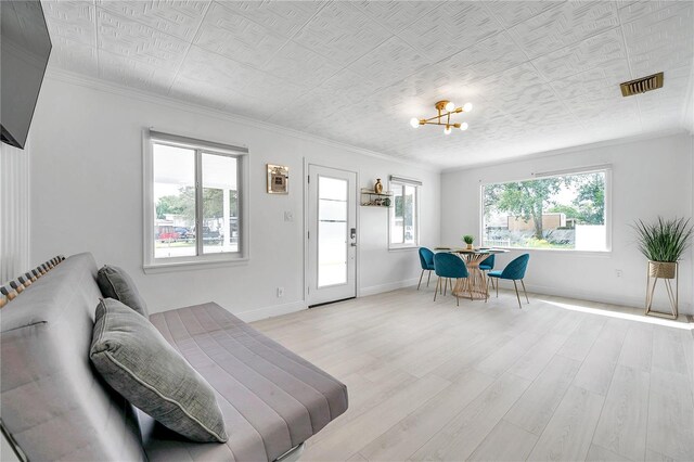 living room featuring a notable chandelier, light hardwood / wood-style floors, and a wealth of natural light